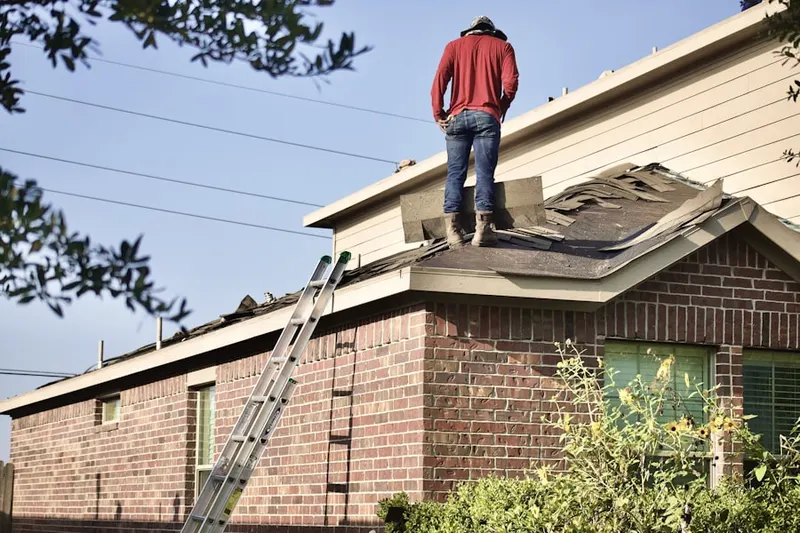 Professional roofer working on a residential roof in Husted